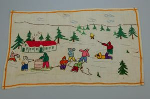 Image: Embroidered place mat with Inuit figures outside MacMillan-Moravian school 